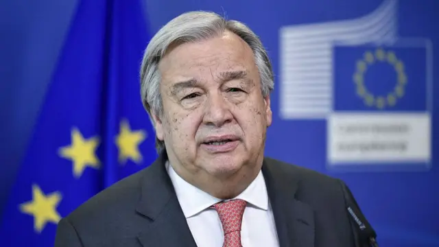 Guterres stands in front of EU flag
