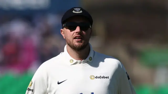 Ollie Robinson in his Sussex jumper, wearing his county cap and sunglasses