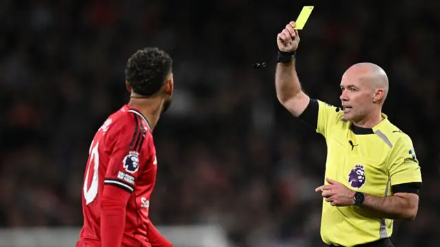 Paul Tierny shows Matheus Cunha a yellow card