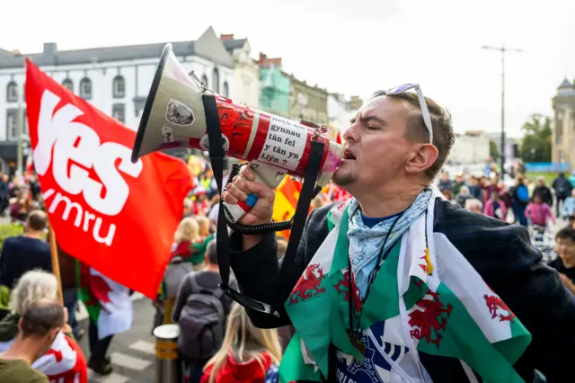 A man holds a bullhorn at a Welsh independence rally