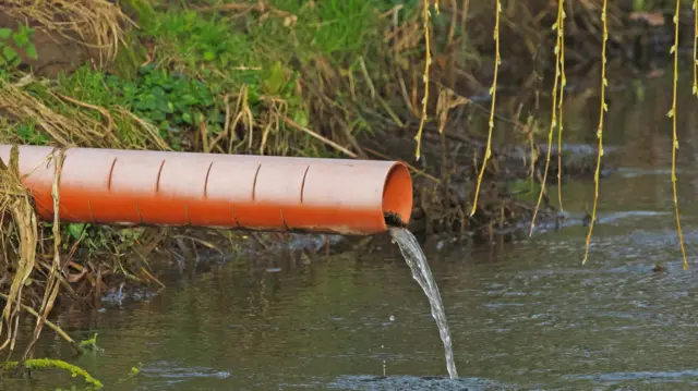 Waste pipe funnelling water into a river