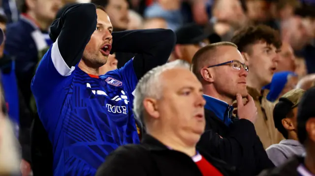 An Ipswich fan has his head in his hands at Fratton Park