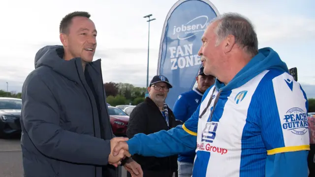 John Terry greets a Colchester fan before their game against Accrington