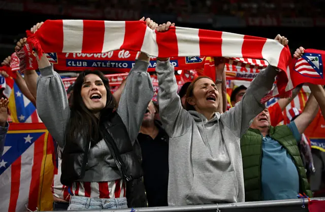 Fans of Atletico de Madrid hold up scarves