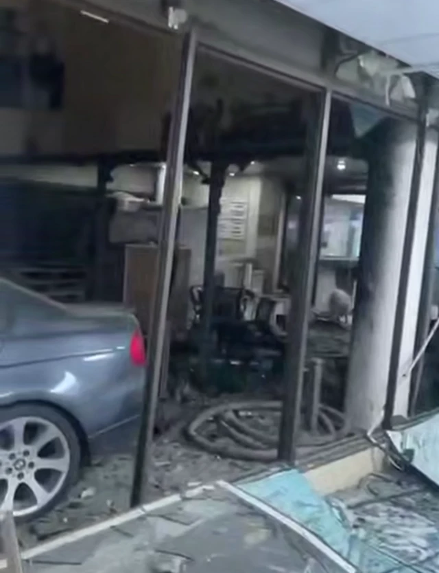 A screenshot showing glass panelled windows blown out and debris lying around