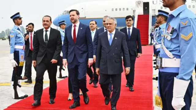 JD Vance walks down a red carpet flanked by Pakistani officials