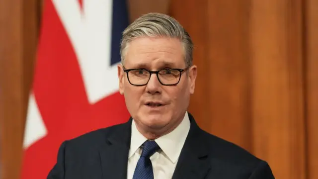 Keir Starmer speaks in front of a UK flag