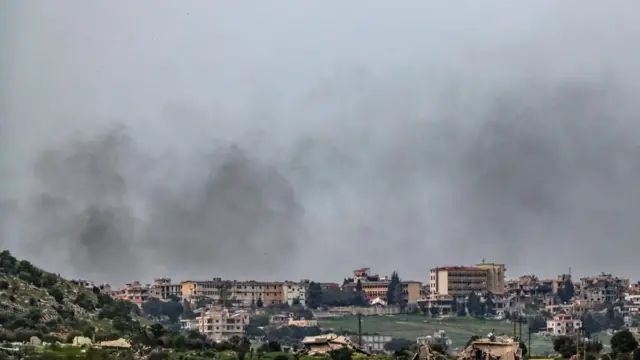 Smoke rises over buildings
