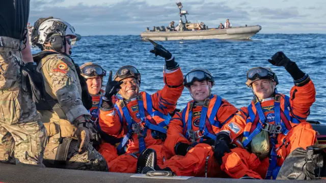 From left to right, NASA astronauts Christina Koch, Victor Glover, Canadian Space Agency astronaut Jeremy Hansen and NASA astronaut Reid Wiseman pose for a photo on the front porch before transiting to amphibious transport dock ship USS John P. Murtha (LPD 26), April 10, 2026. John P. Murtha is underway in the U.S. 3rd Fleet area of operations supporting NASA’s Artemis II mission, retrieving the crew and spacecraft following their return to Earth and splashdown in the Pacific Ocean. NASA's Artemis II mission sent four astronauts on a flight around the moon in the Orion space capsule, marking the first time humans journeyed to deep space in over 50 years. (U.S. Navy photo by Mass Communication Specialist David Rowe)