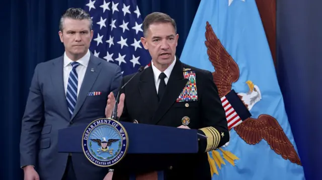 Admiral Brad Cooper with US Defence Secretary Pete Hegseth standing behind him at a press briefing