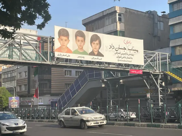 Pictures of a street in Tehran, an overpass with pictures of three children on a board