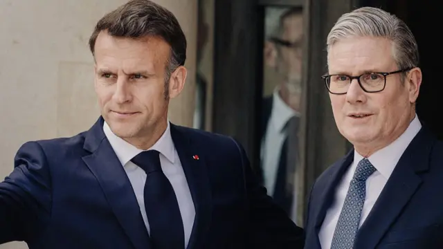 Emmanuel Macron standing beside Keir Starmer, both wearing suits