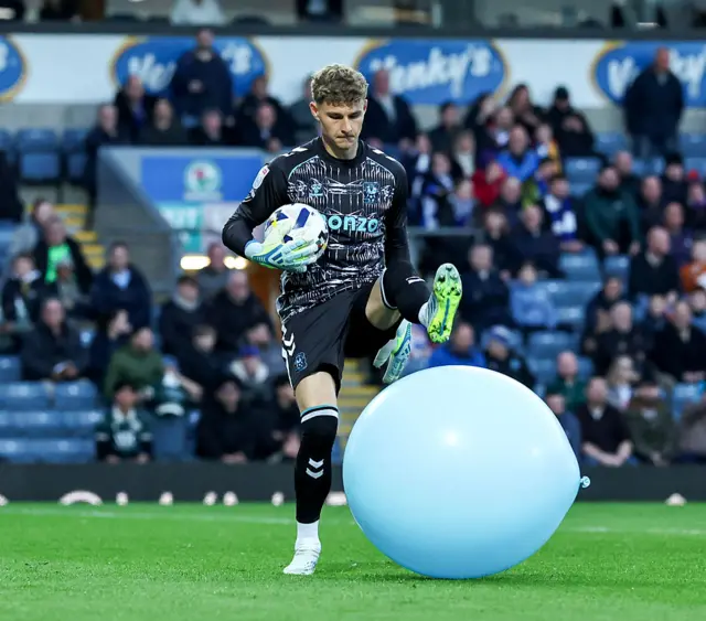 Coventry goalkeeper Chris Rushworth goes to stamp on a giant balloon