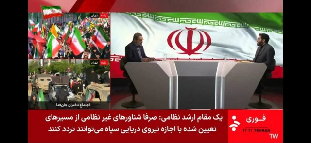 Image from Iranian state TV, showing two men in a studio with Iranian flag