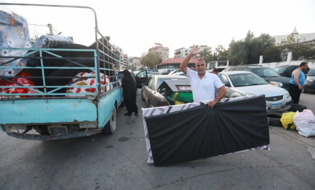 Displaced people pack their belongings, as they prepare to return to their homes after a 10-day ceasefire between Lebanon and Israel went into effect, in Sidon