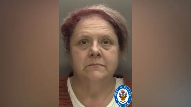 Deborah's mugshot shows her with short faded pink hair