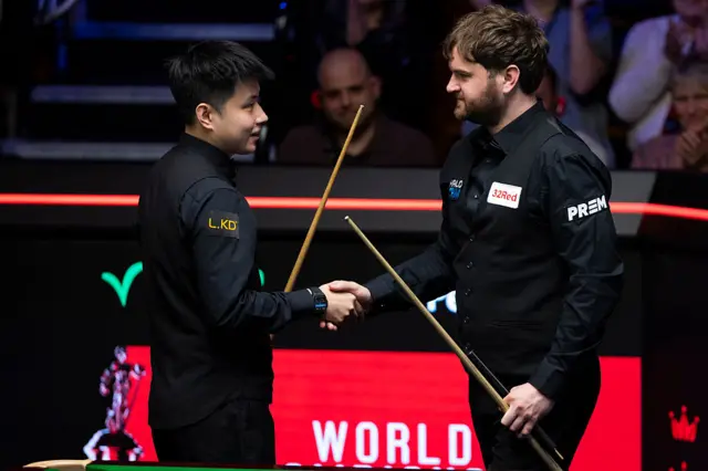 Liam Highfield and Zhao Xintong shake hands after their match