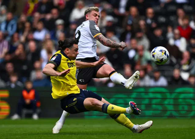 Sam Szmodics of Derby County challenges Ciaron Brown of Oxford United