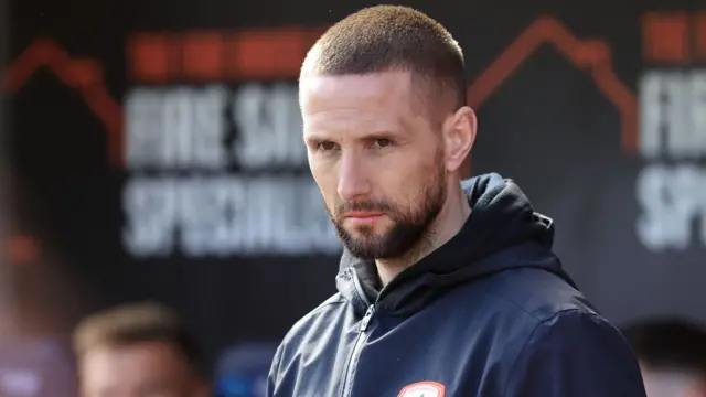 Conor Hourihane wearing a black jacket with the Barnsley club badge on