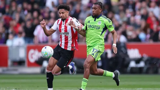 : Kevin Schade of Brentford battles for possession with Alex Iwobi of Fulham