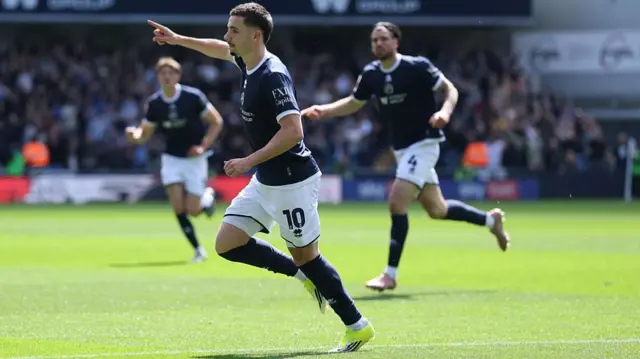 Camiel Neghli runs away with his right arm raised to celebrate his goal for Millwall