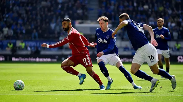Mohamed Salah of Liverpool is challenged by James Garner and Vitaliy Mykolenko of Everton