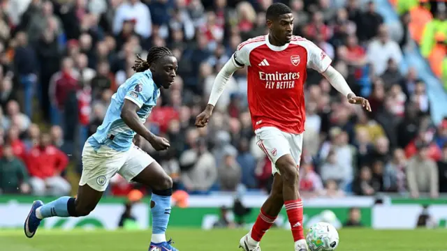 Cristhian Mosquera of Arsenal runs with the ball while under pressure from Jeremy Doku