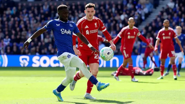 Idrissa Gueye of Everton passes the ball under pressure from Andrew Robertson of Liverpool