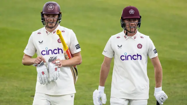 James Sales and Nathan McSweeney of Northamptonshire leave the field due to bad light,
