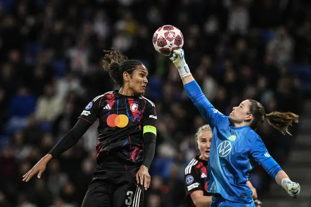 VfL Wolfsburg's German goalkeeper #01 Stina Johannes (R) clears the ball in front of Lyon's French defender #03 Wendie Renard (L) q
