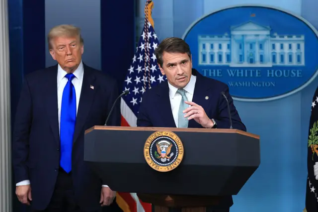 Deputy Attorney General Todd Blanche, joined by President Donald Trump, speaks at a press conference.