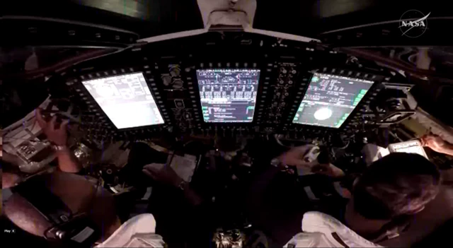 People sit behind panel filled with screens