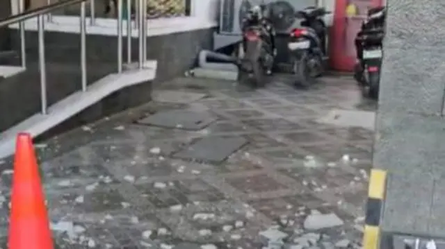 Shattered glass on the ground at Whizz Prime Hotel, Manado