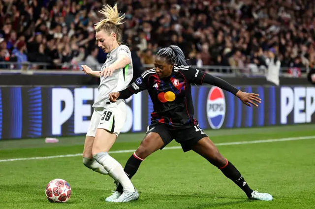 Sarai Linder of VfL Wolfsburg is challenged by Dianni of OL Lyonnes