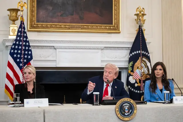 Pam Bondi, Trump and Kristi Noem at the White House with the US flag in the backdrop
