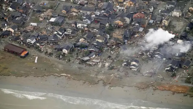Damaged houses next to a beach following a tsunami