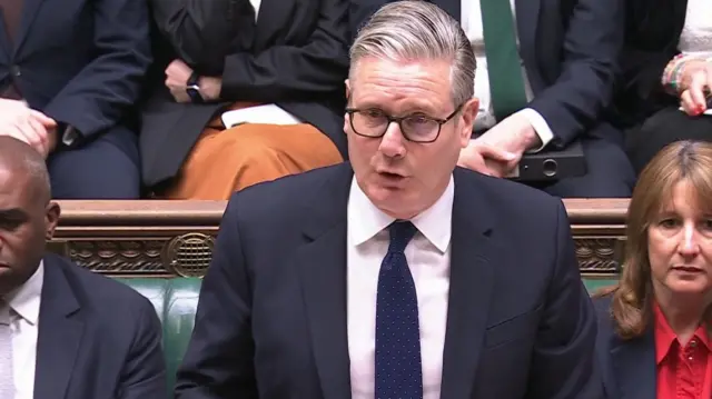 Keir Starmer speaks in Parliament, wearing a suit and tie.