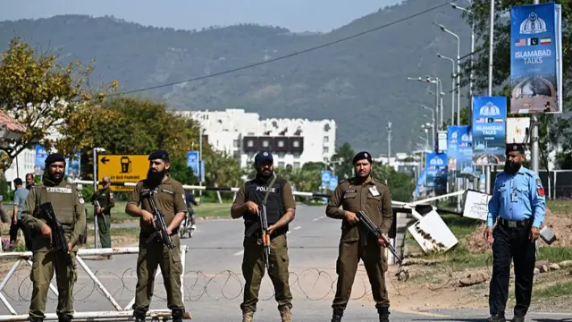 Security personnel stand guard at a security checkpost along a road temporarily closed near the Serena Hotel at the Red Zone area in Islamabad on April 20, 2026