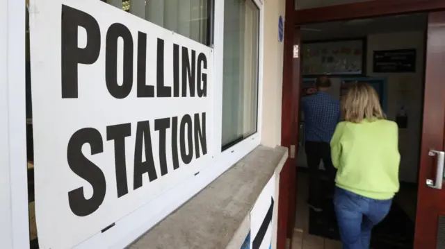 A woman walking into a polling station