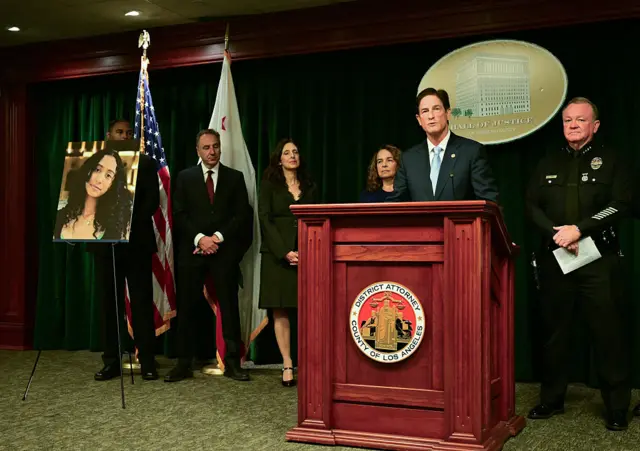 Law enforcement officials stand behind a lectern