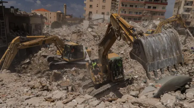 Civil defence members search for bodies under the rubble of buildings hit by an Israeli strike just before the ceasefire, amid a 10-day ceasefire between Lebanon and Israel, in Tyre, southern Lebanon, April 20, 202