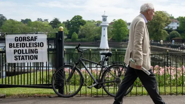 A man walks past a polling station at Roath Park lake, Cardiff