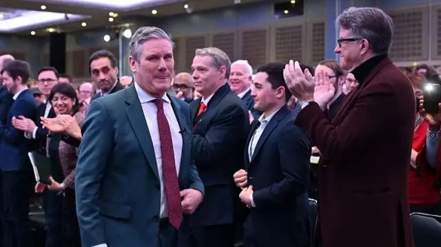 Starmer walks past a row of people including Peter Mandelson