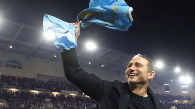 Frank Lampard waving a sky blue flag on the pitch following the win over Portsmouth