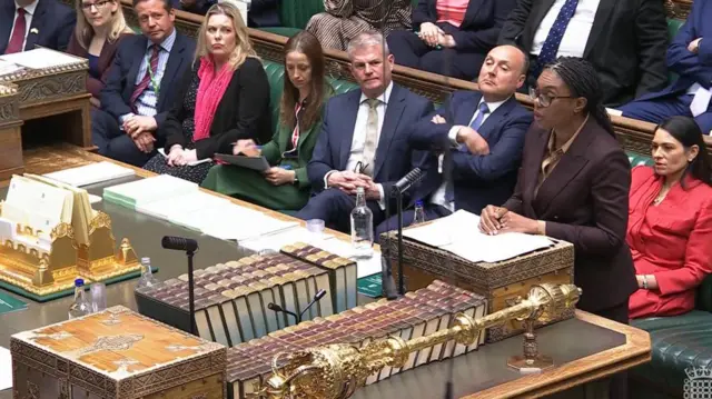 Badenoch standing up while addressing the Commons about the emergency debate, on the front bench