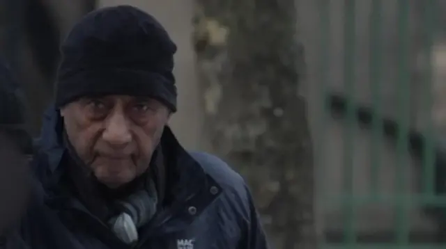 Malcolm Phillips outside court. He is wearing a hat and looking at the camera.