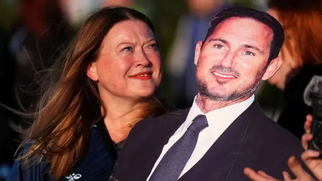 A Coventry fan holds a cardboard cutout of Frank Lampard