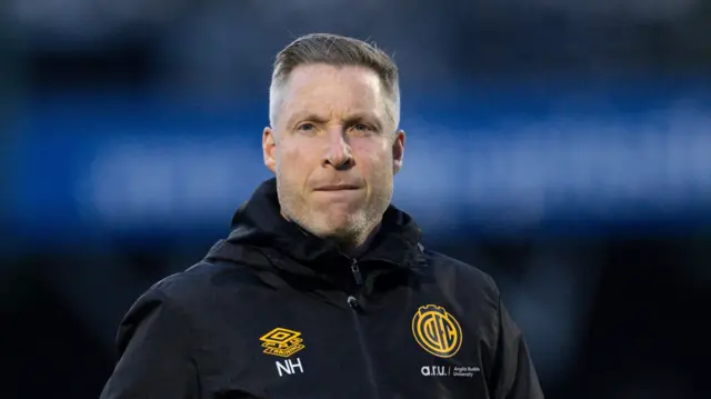 Cambridge United manager Neil Harris wearing a black jacket
