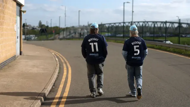 Two Coventry fans arrive at the CBS Arena bearing shirts with the names of Jack Rudoni and Haji Wright