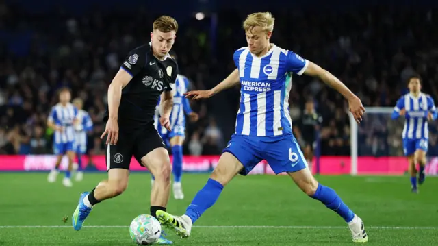 Liam Delap in action with Brighton & Hove Albion's Jan Paul van Hecke